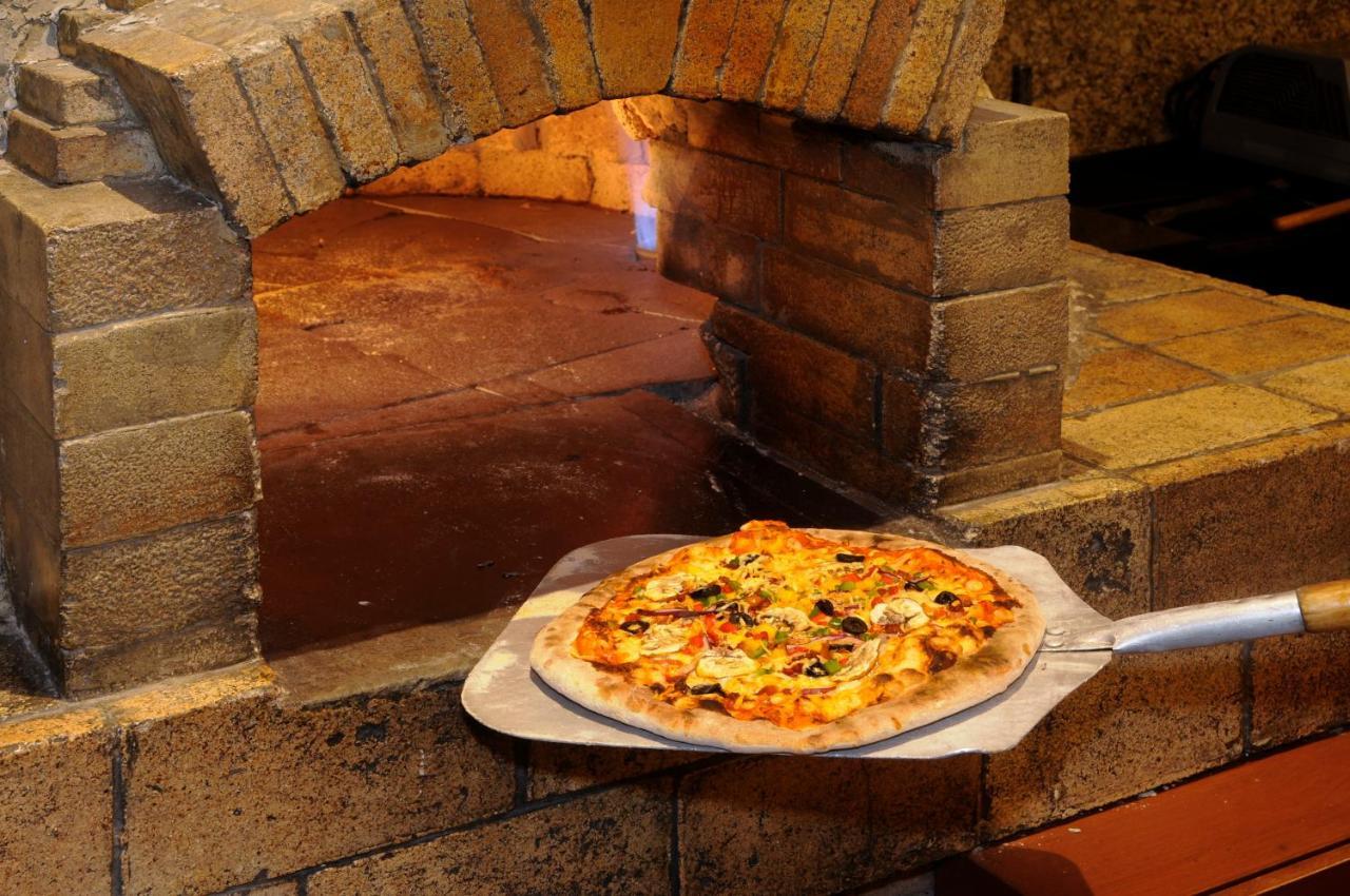 Belair Unique Mexico City Wtc, Trademark By Wyndham Kültér fotó Pizza being removed from a wood-fired oven